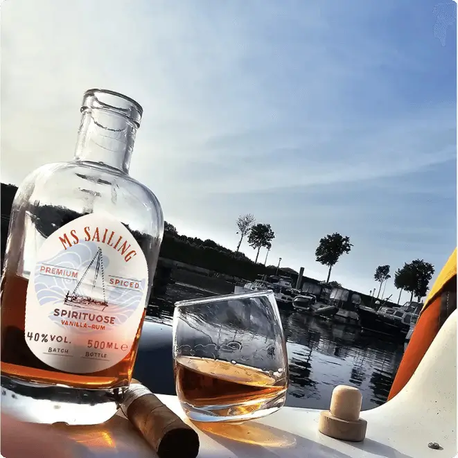 Flasche Rum mit Meer und Segelboot im Hintergrund